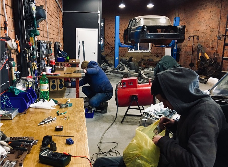 люди работают в гараже