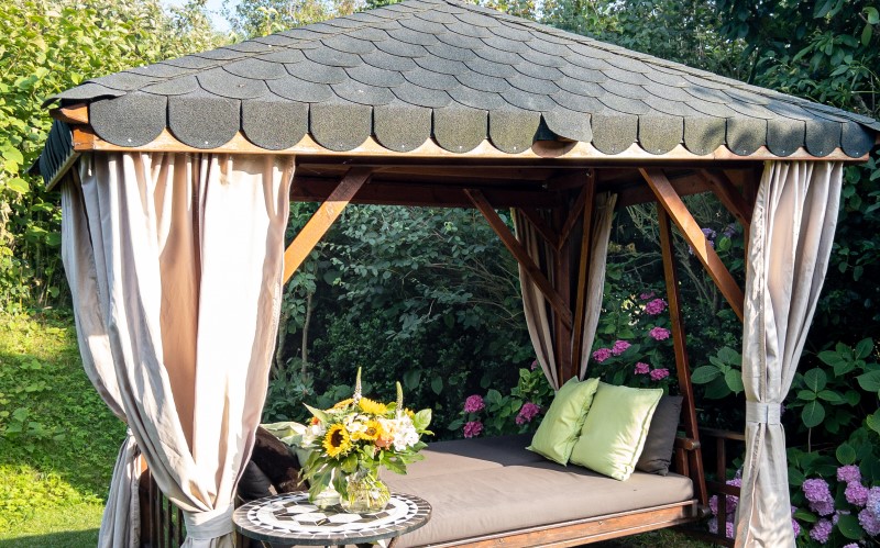В некоторых случаях для летней беседки вполне достаточно теневого навеса из прочного текстиля либо листа поликарбоната